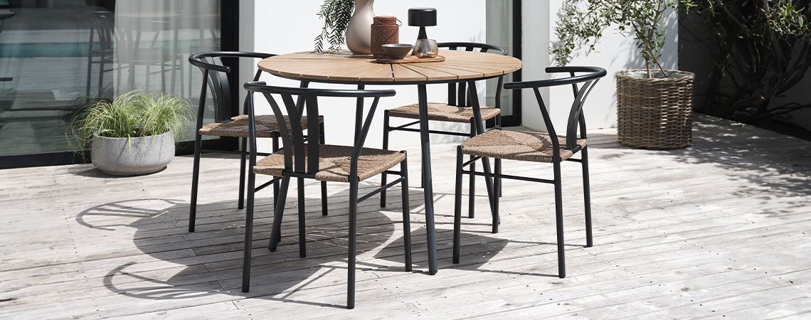 Mesa de jardín de madera y negra y cuatro sillas de jardín en una terraza