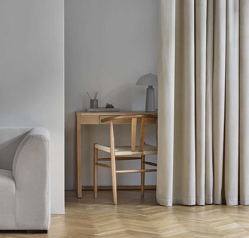 Cortinas AUSTRA, silla GUDERUP y escritorio RY Cortinas beige que separan un despacho con escritorio y silla de un salón
