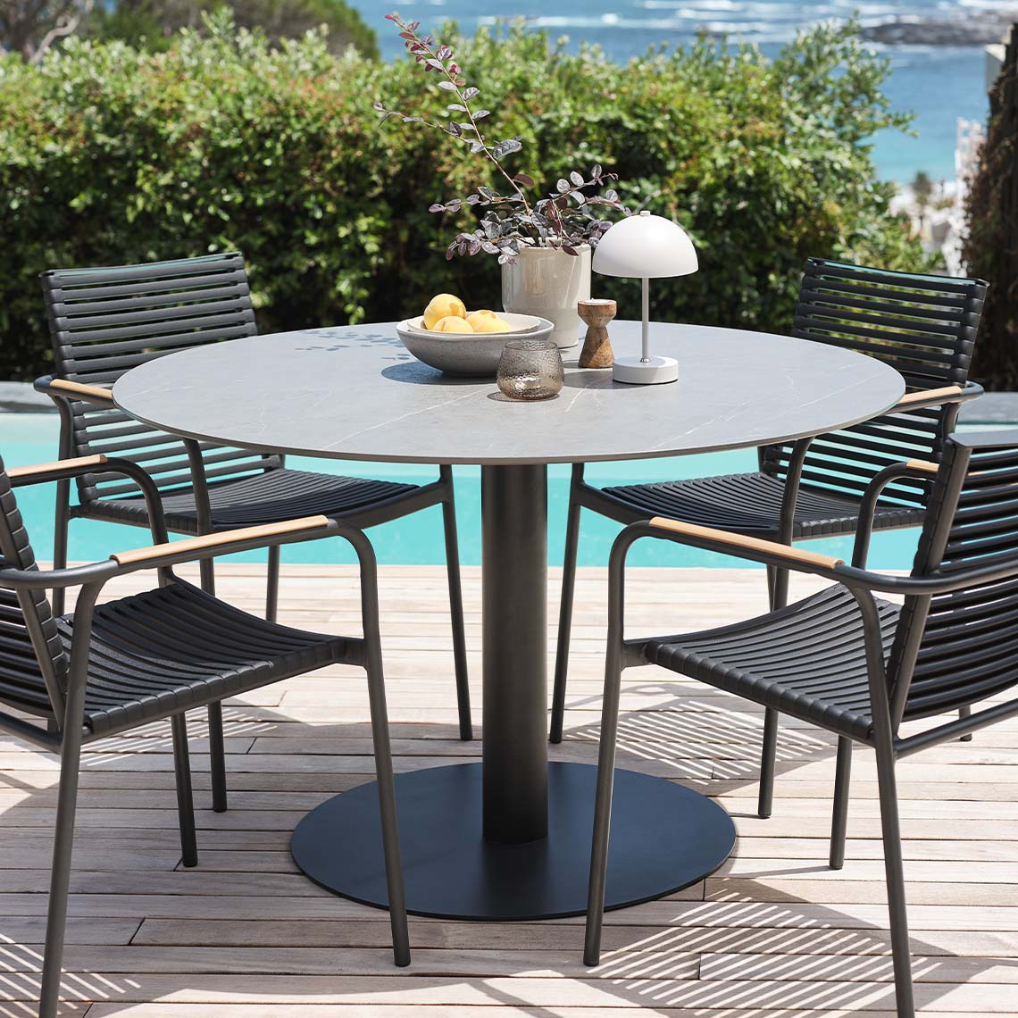 Mesa de jardín con tablero de fibrocemento y sillas de jardín